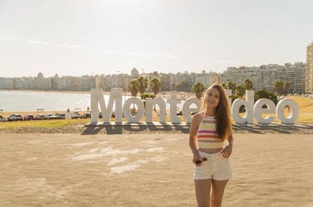 Mujer posando frente a letrero de Montevideo