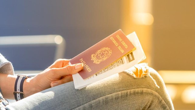 silueta con pasaporte italiano en mano