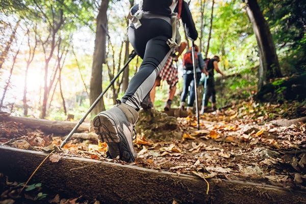 mujer excursionista con palos de trekking subiendo