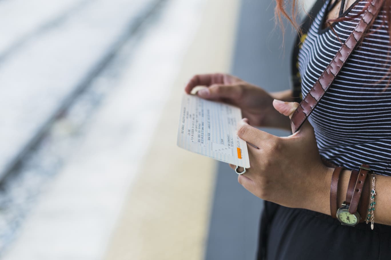Imagem de mulher segurando passagens aéreas impressas, em texto sobre como comprar passagens aéreas mais baratas em 2025