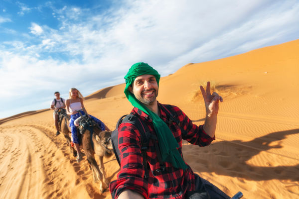 Turista feliz tomando una selfie en las dunas del Parque Nacional del Sahara.