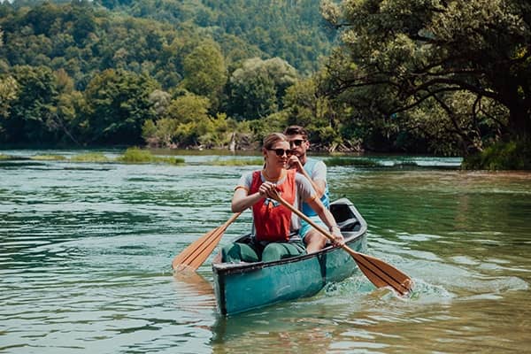 Imagem de homem e mulher andando de barco no rio
