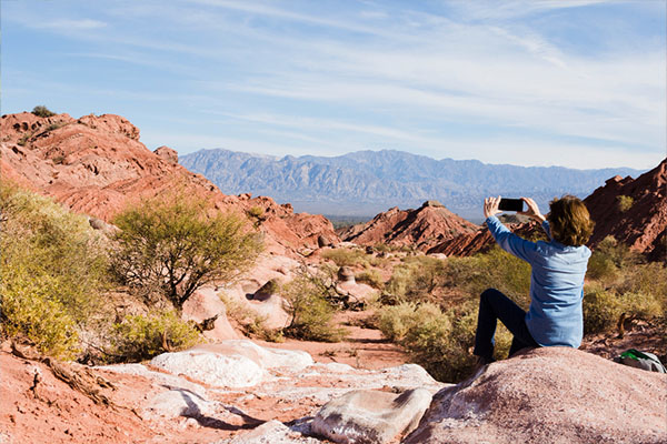 Mujer tomando una fotografía a un paisaje árido