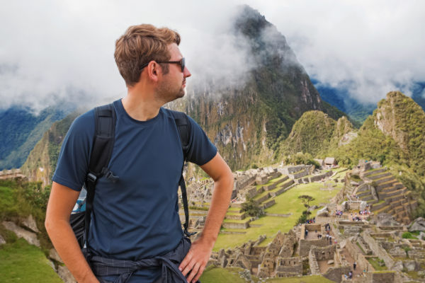 Viajero contemplando las ruinas de Machu Picchu, uno de los principales destinos turísticos de Perú.