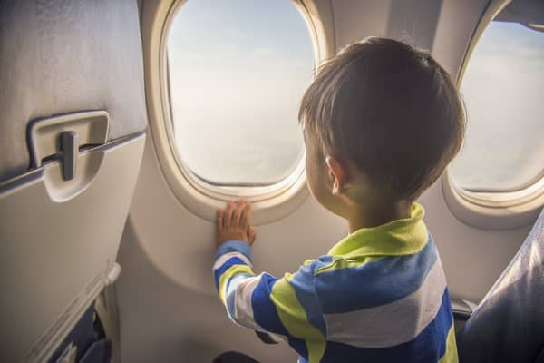 niño mirando por la ventana del avión