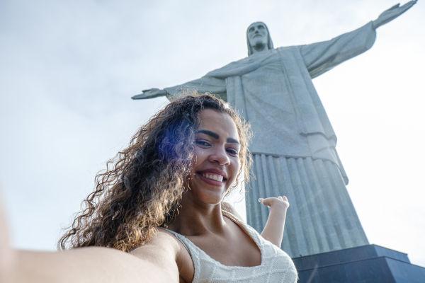 mujer turista posando con el Cristo Redentor en Río de Janeiro.