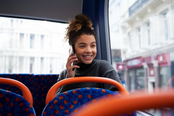 imagem de mulher falando em celular em ônibus, para falar sobre roteiro de viagem para Portugal e Espanha