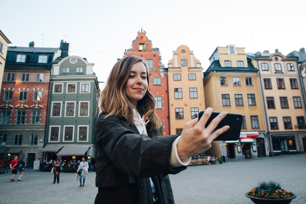Mujer tomándose una selfie en el centro histórico de Brujas, Bélgica