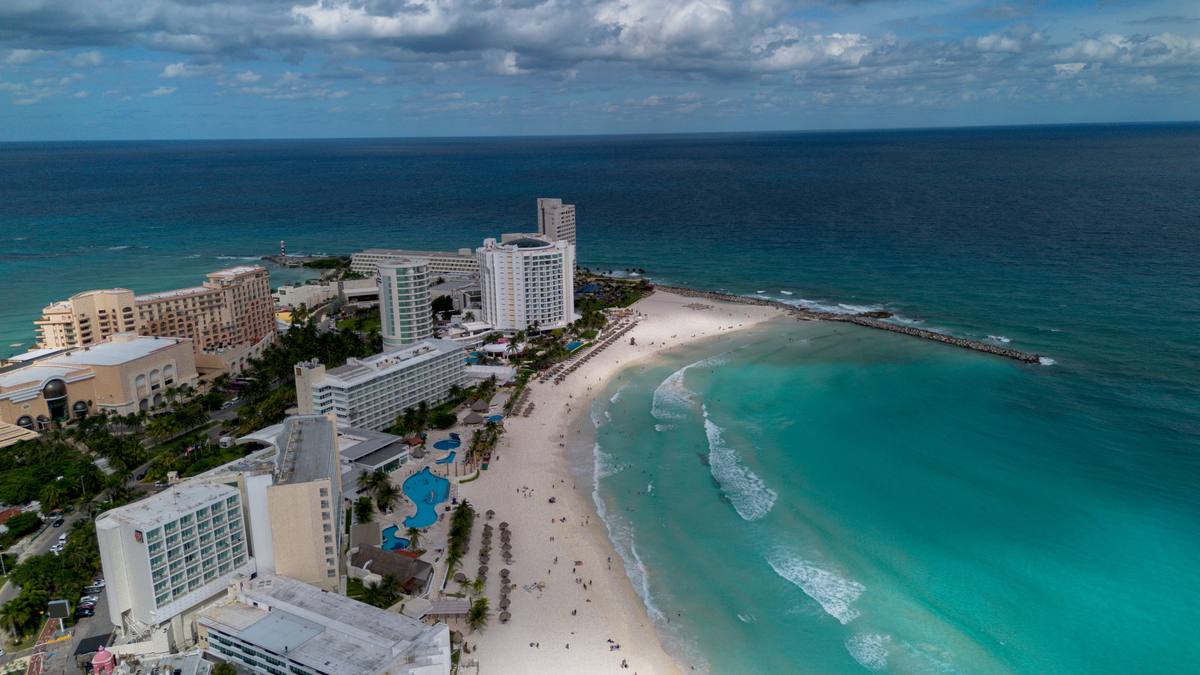 Vista aérea de Cancún com hotéis à beira-mar, praia de areia branca e mar azul-turquesa, destacando o destino turístico para quem busca saber se Cancún precisa de passaporte.