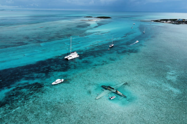 Barcos anclados alrededor de un accidente aéreo en Norman's Cay, Bahamas