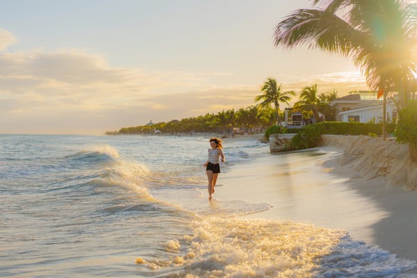 Mujer corriendo en la playa al atardecer de Cancún