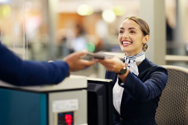 Asistente de pasajeros recibiendo un check-in en la sala de embarque. 