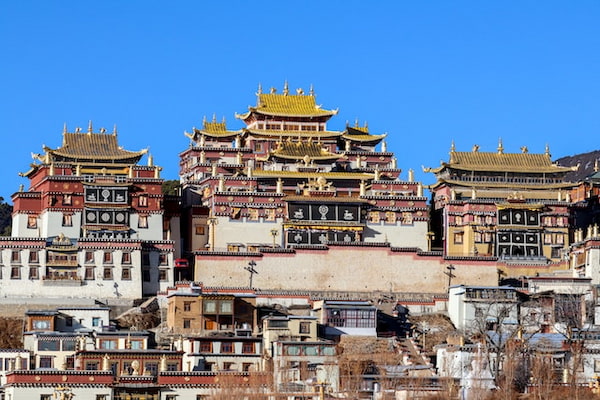 Grupo de edifícios com um céu azul ao fundo na Região Autônoma do Tibete, na China.