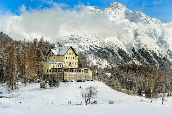 Vista de un hotel en St. Moritz, Suiza, en pleno invierno con montañas nevadas de fondo