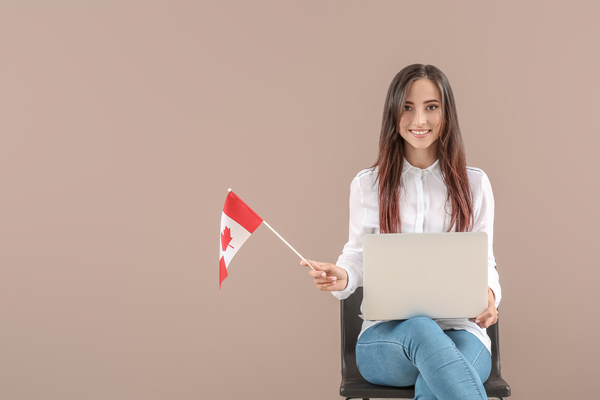 chica con una computadora sosteniendo bandera canadiense