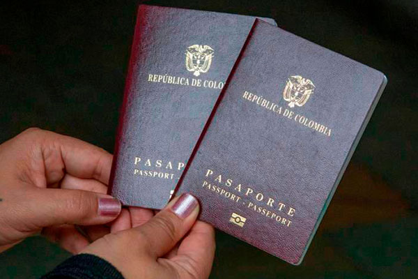 Dos manos sosteniendo dos pasaportes colombianos