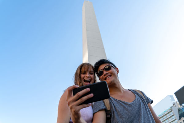 Turistas tomándose una selfie frente al Obelisco de Buenos Aires.