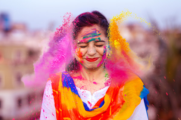 Retrato de feliz mujer india celebrando Holi con colores pólvora o gulal