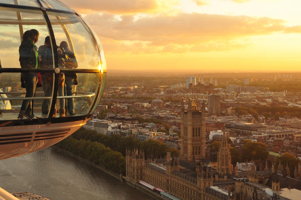 Pasajeros dentro de una cápsula del London Eye con el Big Ben de fondo en el horizonte de Londres.