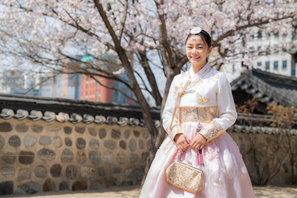 Mujer coreana con una sonrisa en traje tradicional de hanbok en el antiguo palacio Gyeongbokgung en la ciudad de Seúl, Corea del Sur.
