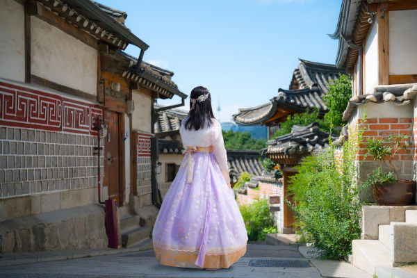Una hermosa joven asiática, vestida con un tradicional hanbok coreano, está viajando por la aldea de Bukchon Hanok en Seúl, Corea del Sur.