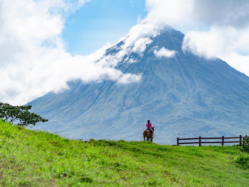 Vista panorâmica do Vulcão Arenal cercado por floresta tropical na Costa Rica, um dos destinos mais visitados do país para trilhas e ecoturismo.