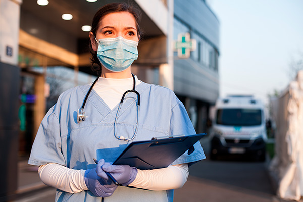 Doctora esperando a un paciente en la zona de ambulancias, afuera de un hospital