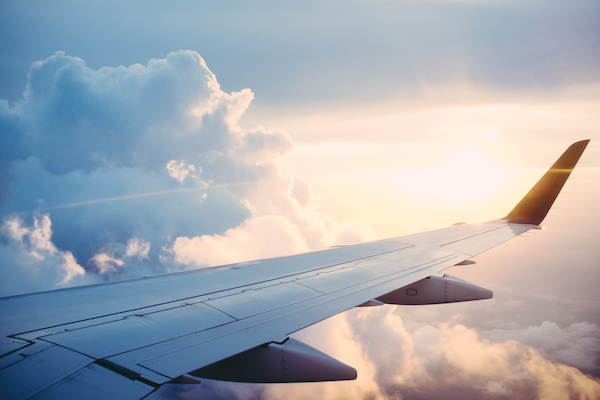 Asa direita de um avião sobrevoando as nuvens.                      