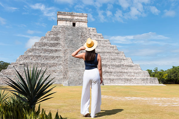 Mujer turista frente a la Pirámide de Kukulcán, Chichén Itzá