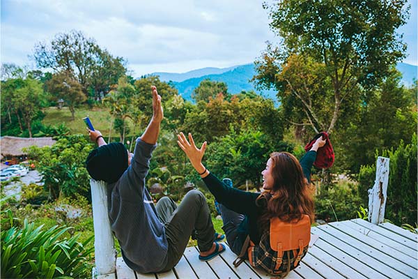 Una pareja con los brazos abiertos disfrutando de un paisaje