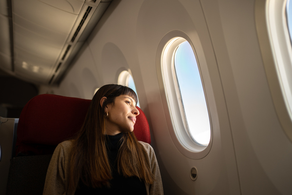 Mujer mirando por la ventana del avión