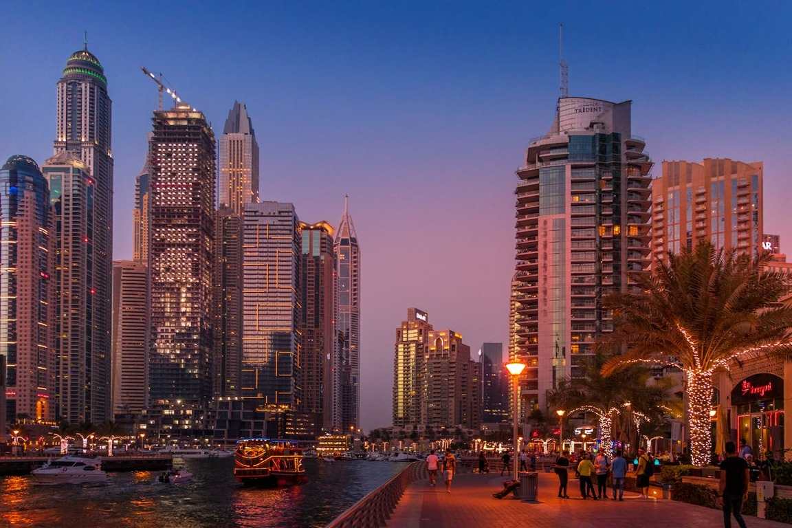 Imagem da Dubai Marina ao pôr do sol com prédios iluminados, ilustrando artigo sobre Dubai precisa de visto.
