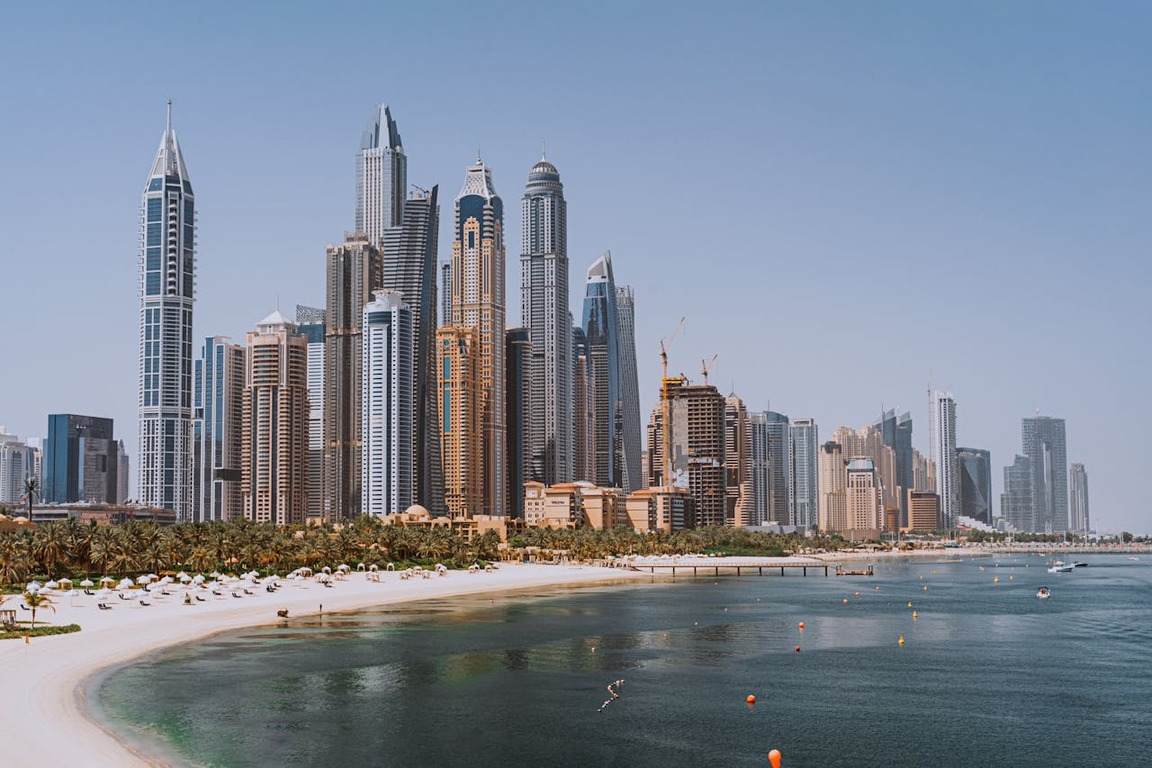Foto diurna de Dubai com praia e arranha-céus, ilustrando artigo sobre Dubai precisa de visto