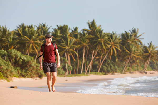 un hombre caminando por la orilla de una playa caribeña