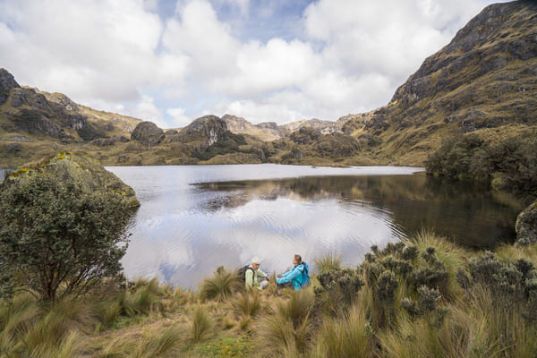 Pareja mayor sentado y disfrutando de la hermosa naturaleza en el Lago en el Parque Nacional El Cajas, Ecuador