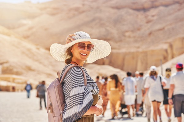 Mujer turista sonriendo a cámara en una fila en el Valle de los Reyes en Luxor, Egipto.