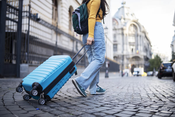 joven llevando su maleta por la ciudad