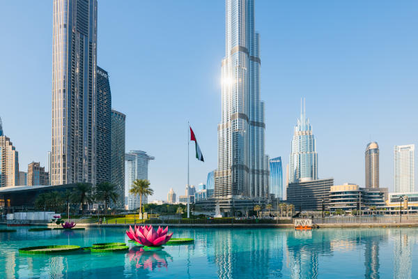 Vista del lago Burj Khalifa con flores decorativas en el agua a los pies del rascacielos Burj Khalifa en un día soleado en Dubai, Emiratos Árabes Unidos