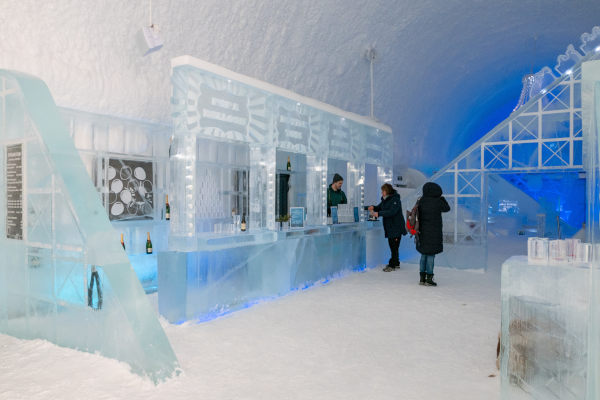 Bar de hielo con algunas personas en el interior del ICEHOTEL de Jukkasjarvi, Suecia.