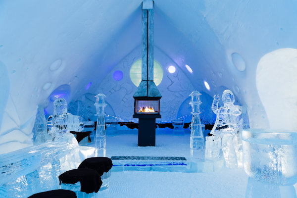 Chimenea encendida en el bar con esculturas de hielo en el Hôtel de Glace en Québec, Canadá.