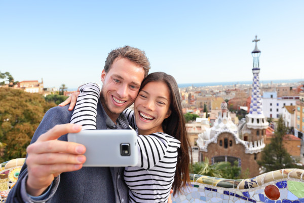 Pareja de turistas posando para una selfie en el Parque Guell, Barcelona, España.