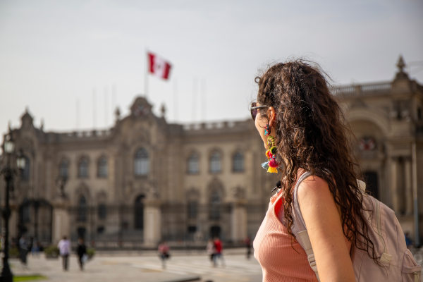 Mujer turista con mochila mirando la Catedral de Lima en Lima, Perú, en un día nublado.