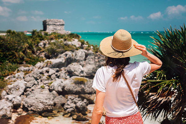 Mujer observando las ruinas de Tulum, México