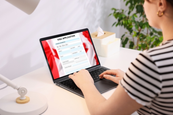 Mujer mexicana que aplica a la eTA Canadá de forma digital en su laptop.
