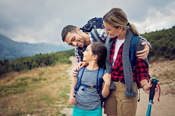 Familia de viaje haciendo senderismo en la montaña.