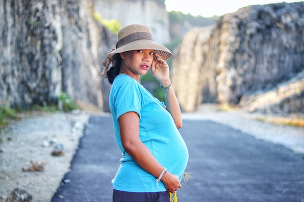 mulher asiática grávida usando chapéu                     