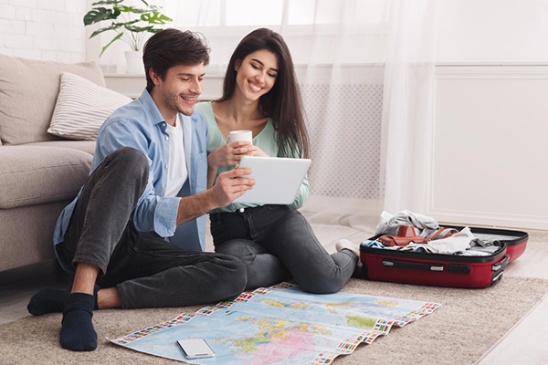 Pareja planificando viaje con un mapa y una tablet