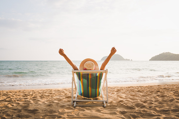 Mujer relajándose en una reposera en la playa