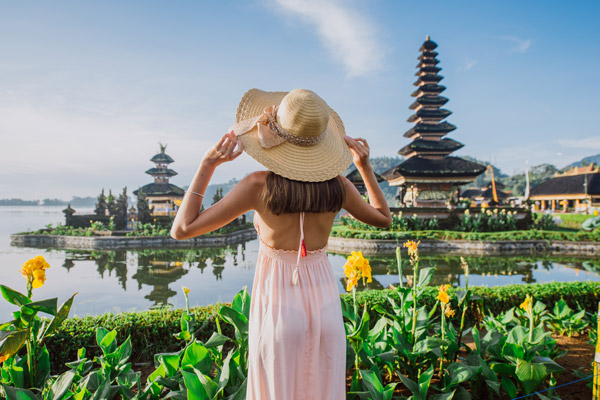 Turista con sombrero observando un templo en Bali