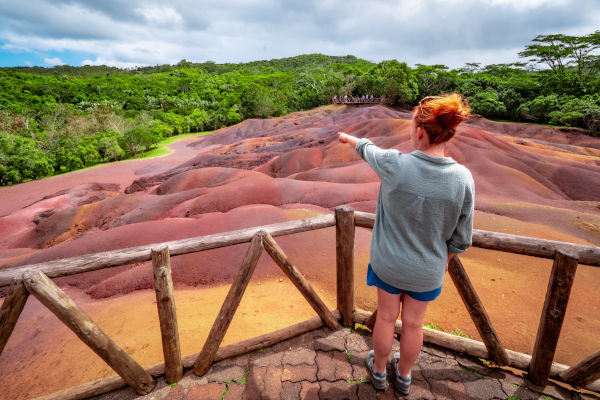 Mujer turista recorriendo la formación geológica Tierra de los Siete Colores en Chamarel.